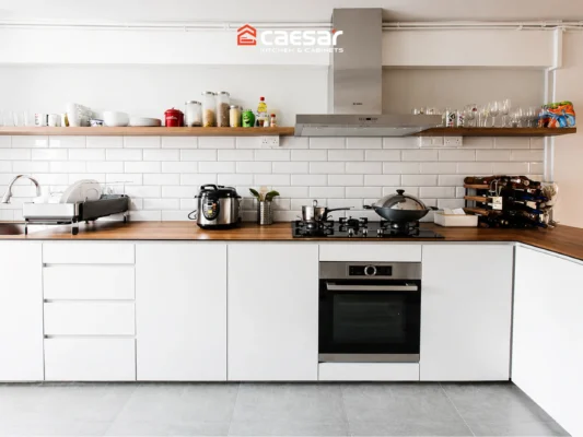 Thiết kế bếp không tủ trên với hệ tủ dưới màu trắng, thiết bị âm và mặt bàn gỗ